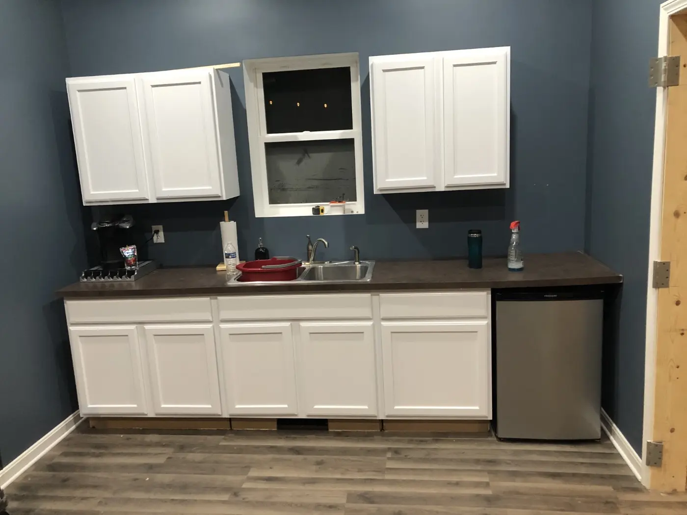 Defunk Studios kitchenette with cabinets, sink, coffee maker and refrigerator